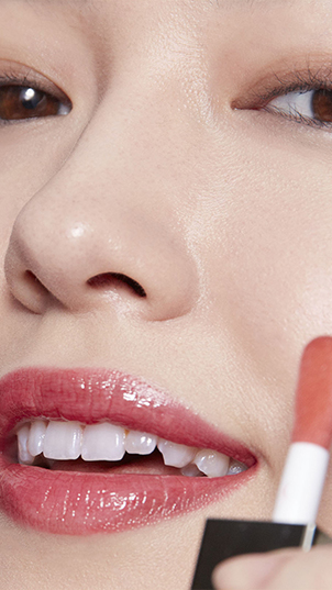 femme appliquant un rouge à lèvre Clarins